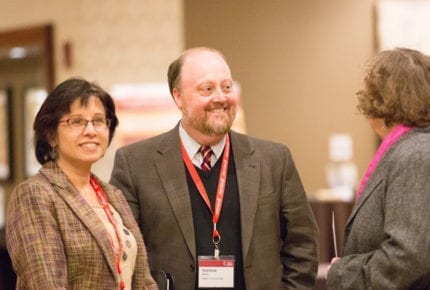 three professionals chat at a conference