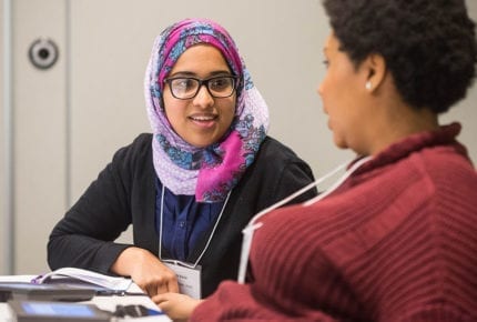 two students facing each other talking