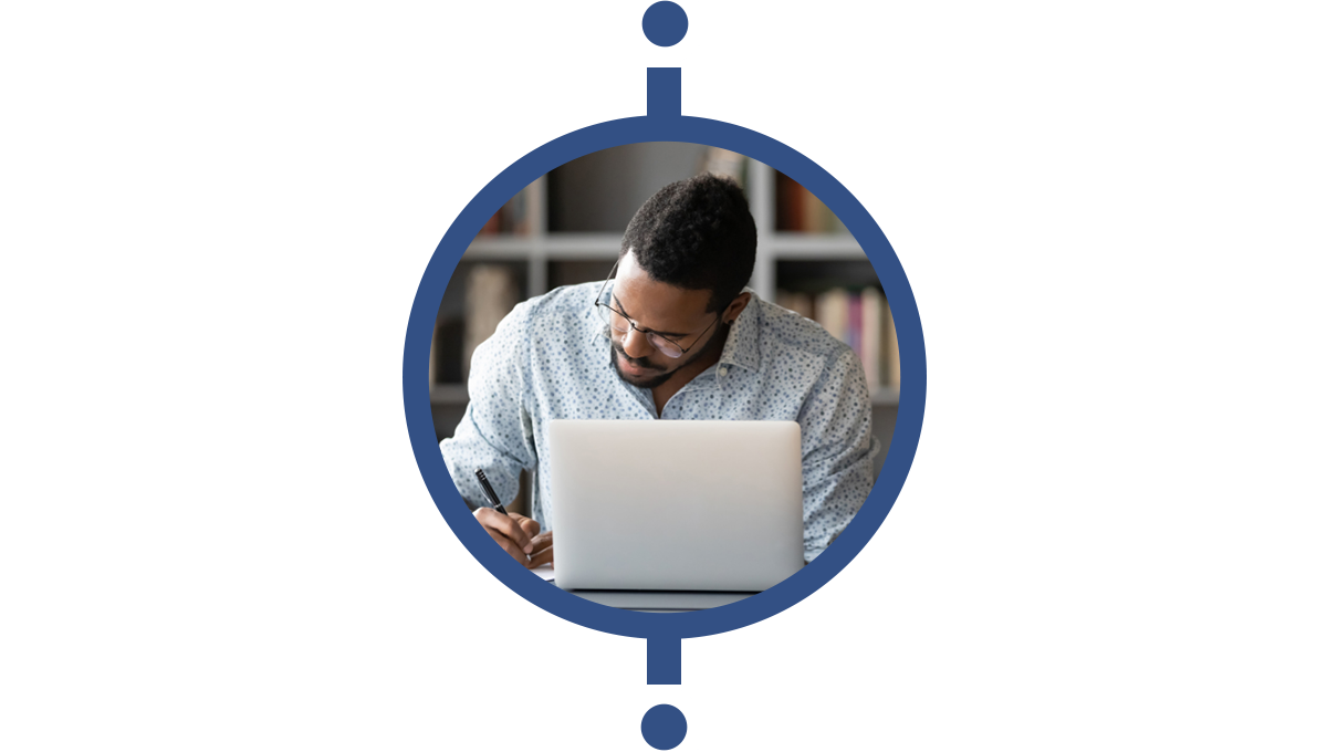 a man sits behind a computer writing